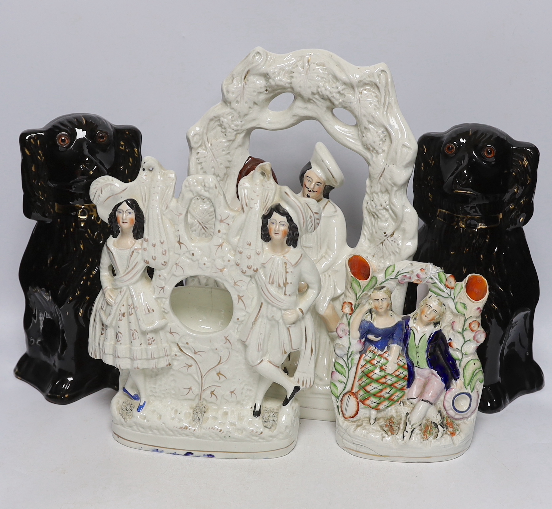 A Staffordshire watch-stand figural group, pair of comforters and two others, largest 34cm high